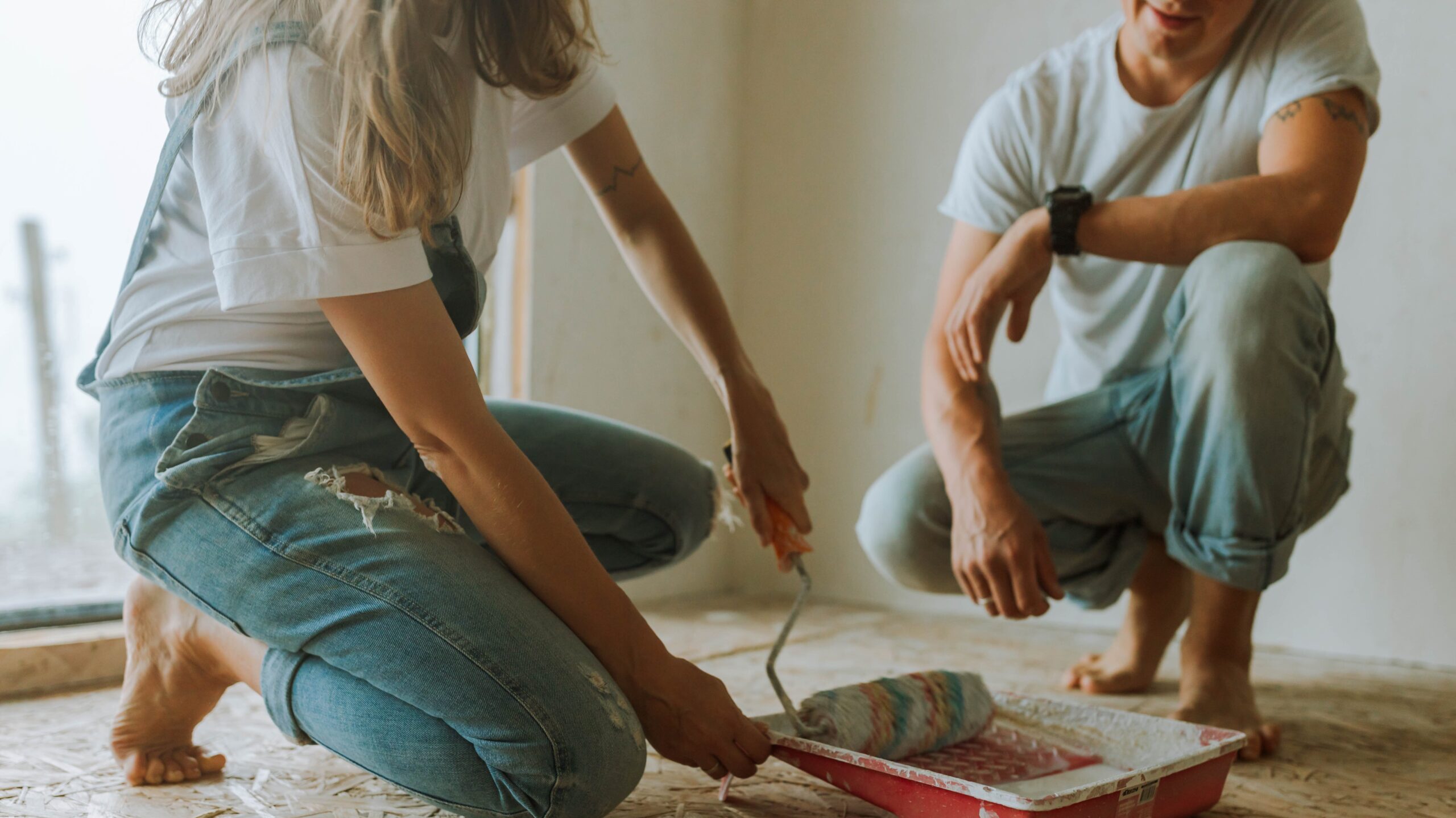 man and woman with paint roller and paint tray