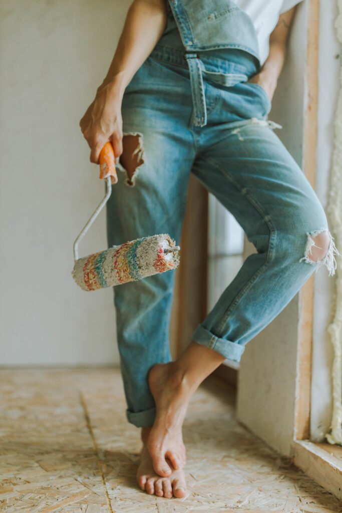 woman with paint roller leaning against the wall